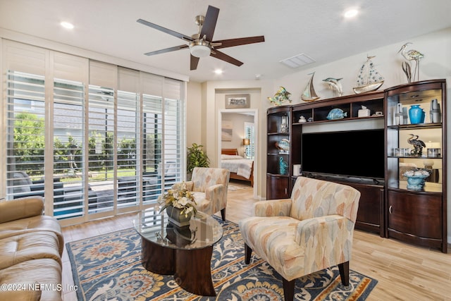 living room with ceiling fan and light hardwood / wood-style floors