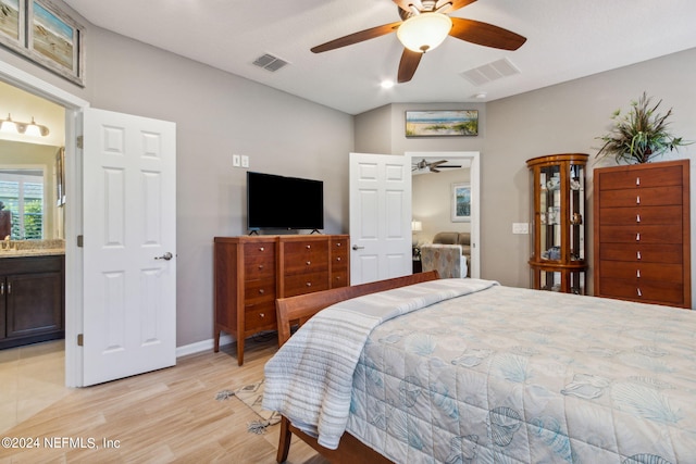 bedroom with lofted ceiling, ceiling fan, connected bathroom, and light hardwood / wood-style floors