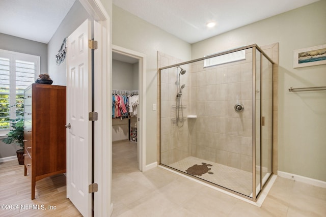 bathroom featuring tile patterned flooring and an enclosed shower