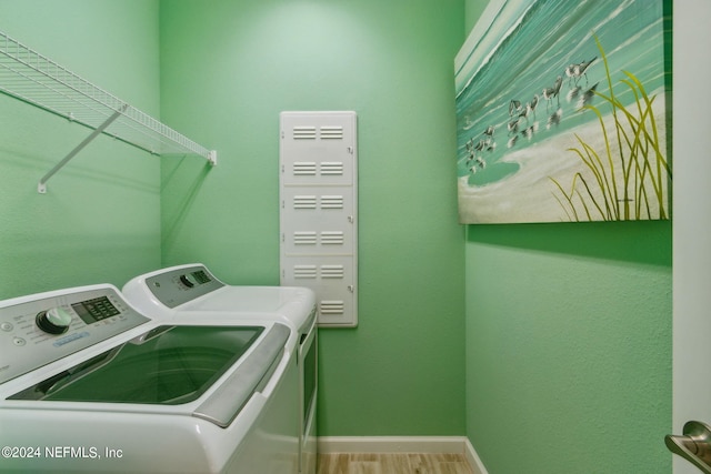 laundry area with separate washer and dryer and hardwood / wood-style floors