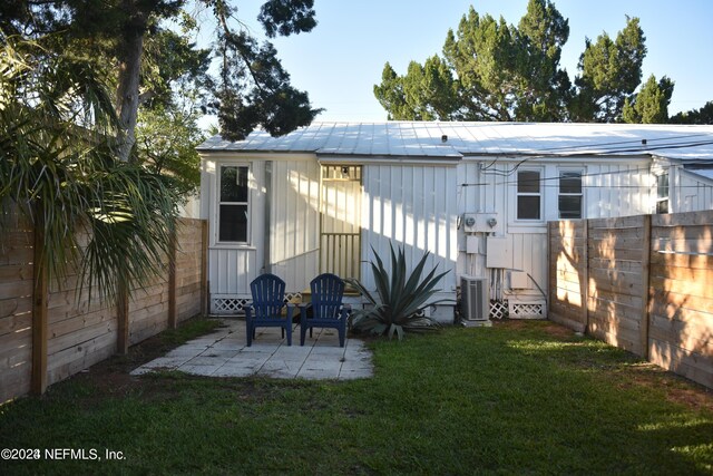 back of property with a patio, central AC unit, and a lawn