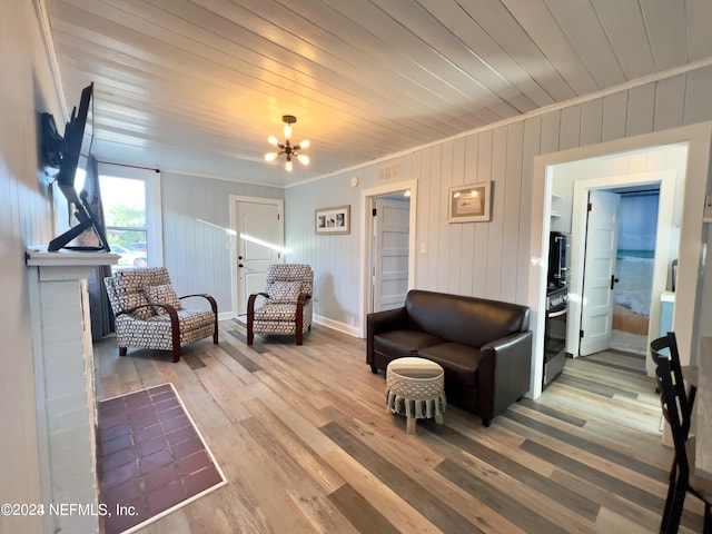 living area featuring visible vents, wooden ceiling, crown molding, light wood-type flooring, and a notable chandelier