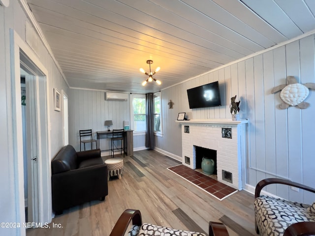 living area with a notable chandelier, ornamental molding, a brick fireplace, an AC wall unit, and wood finished floors