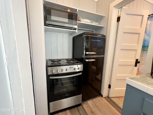 kitchen with appliances with stainless steel finishes, light countertops, and light wood-style flooring