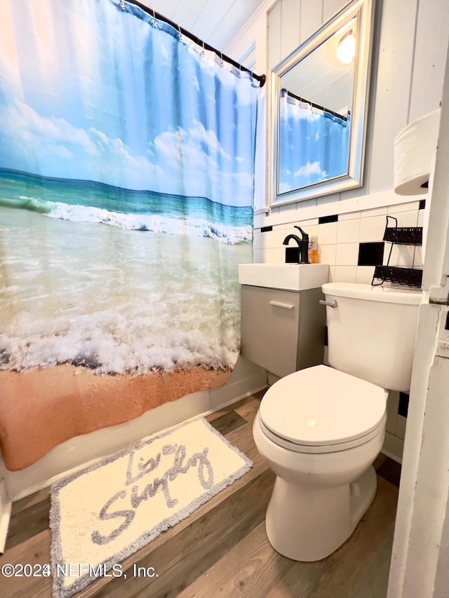 full bathroom with toilet, a shower with shower curtain, tile walls, and wood finished floors