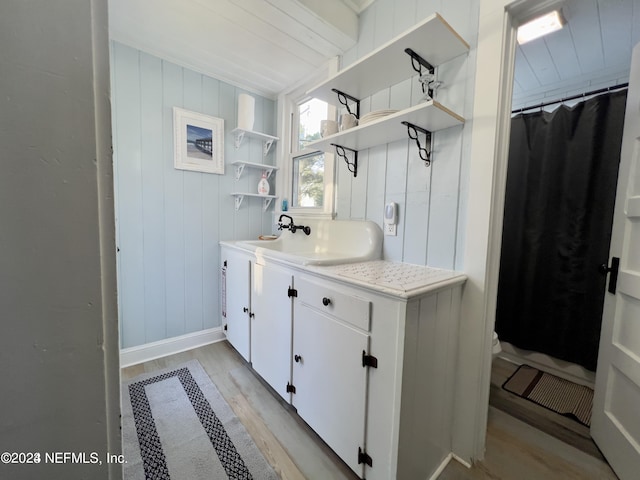 full bath with a shower with shower curtain, wood finished floors, and vanity