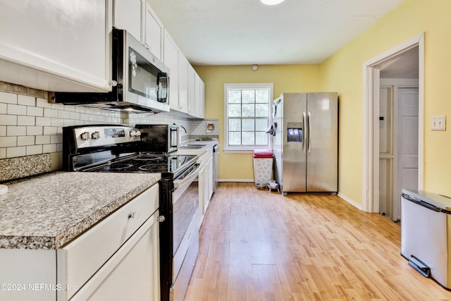 kitchen with white cabinetry, sink, stainless steel appliances, decorative backsplash, and light wood-type flooring