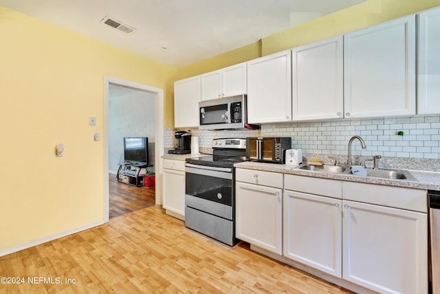 kitchen featuring backsplash, sink, white cabinetry, and stainless steel appliances