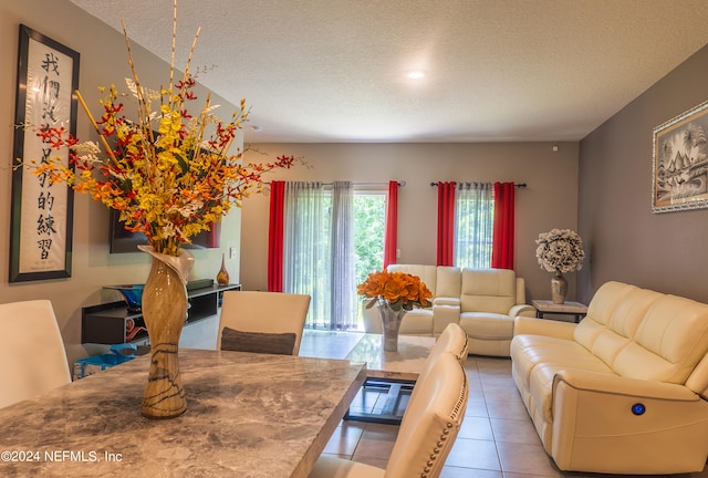 dining space with light tile patterned flooring and a textured ceiling