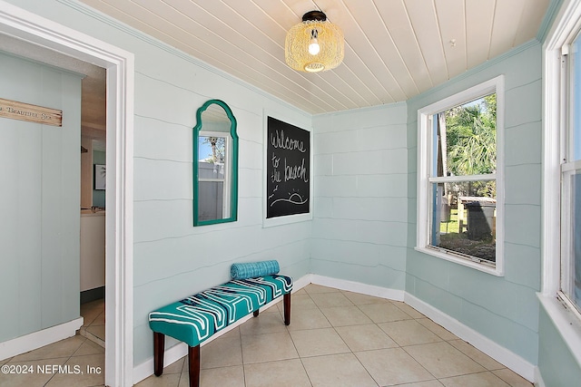 sitting room featuring crown molding, light tile patterned floors, and wood ceiling