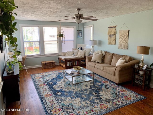 living room featuring ceiling fan, dark hardwood / wood-style floors, and a textured ceiling