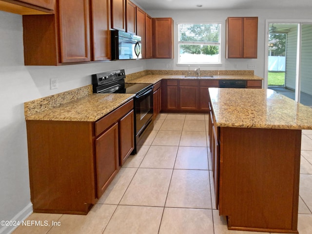 kitchen with sink, light stone counters, light tile patterned floors, a kitchen island, and black appliances