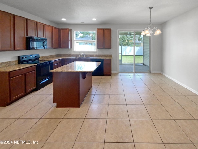 kitchen featuring pendant lighting, light tile patterned floors, light stone countertops, black appliances, and a kitchen island