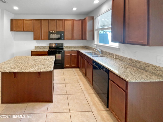 kitchen featuring light stone counters, sink, light tile patterned floors, and black appliances