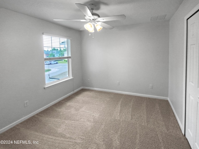 empty room featuring carpet floors and ceiling fan