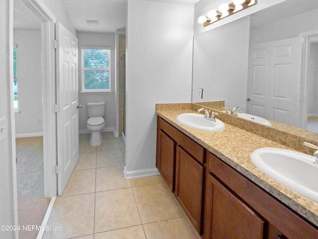 bathroom featuring vanity, a shower with shower door, tile patterned floors, and toilet