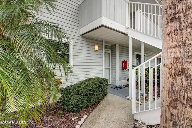 view of exterior entry featuring a balcony