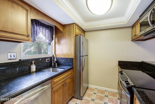 kitchen with brown cabinets, a raised ceiling, appliances with stainless steel finishes, ornamental molding, and a sink