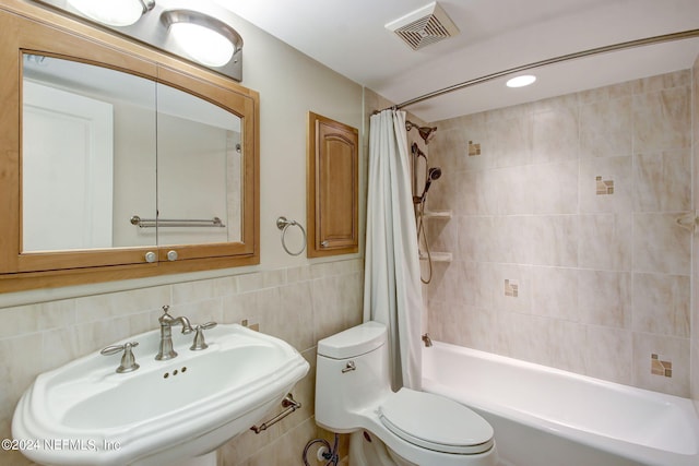 full bathroom featuring shower / bathtub combination with curtain, toilet, tile walls, decorative backsplash, and sink