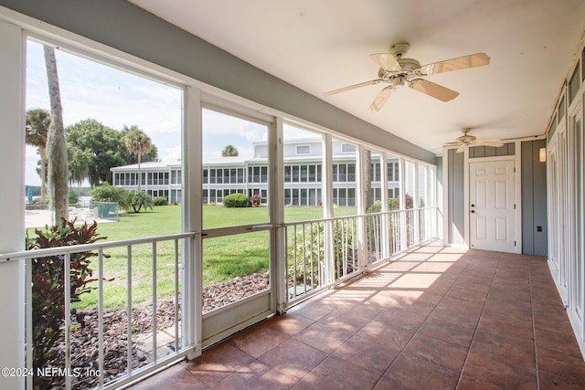 unfurnished sunroom with ceiling fan