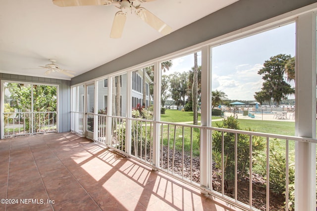 unfurnished sunroom featuring a wealth of natural light and ceiling fan