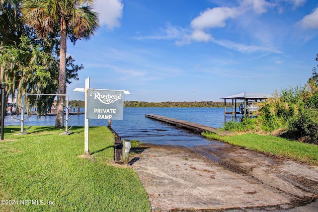 view of dock featuring a water view and a yard