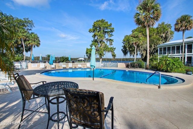 pool with a patio and fence