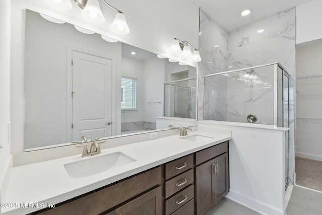 bathroom featuring a shower with shower door and vanity