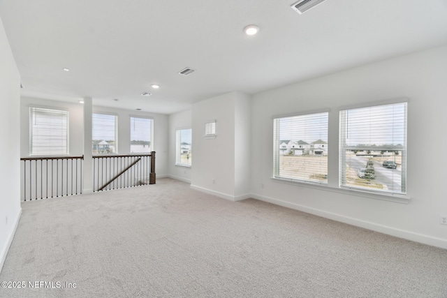 unfurnished room with plenty of natural light and light colored carpet