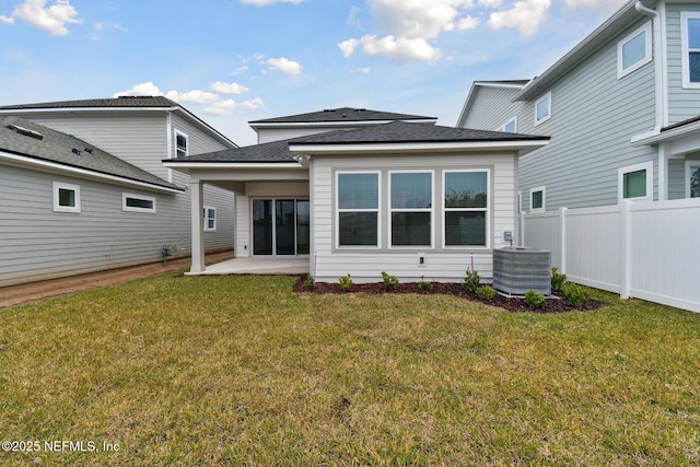 back of house with central air condition unit, a lawn, and a patio