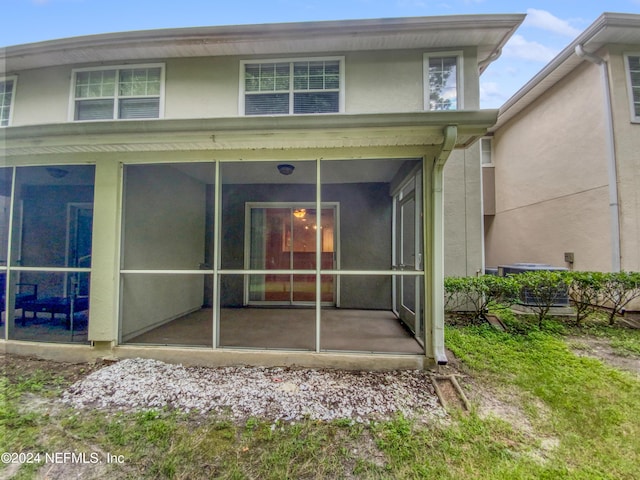 back of house featuring a sunroom and central AC