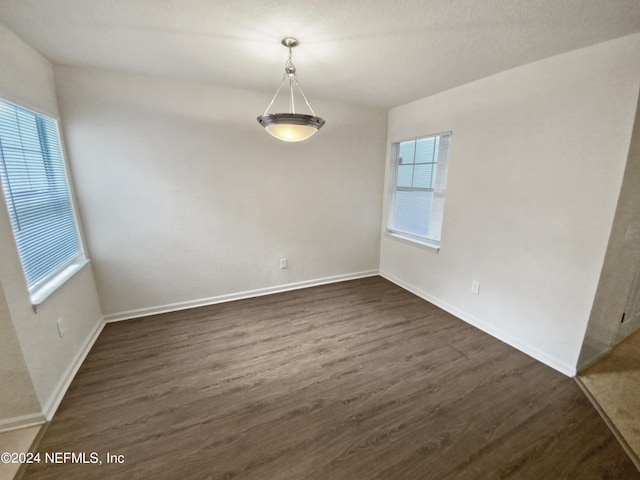 unfurnished dining area featuring dark hardwood / wood-style floors and a wealth of natural light