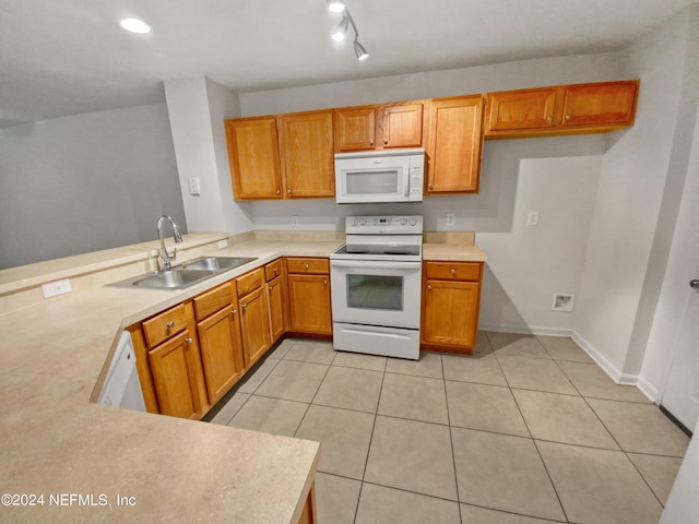 kitchen featuring sink, white appliances, light tile patterned floors, and kitchen peninsula