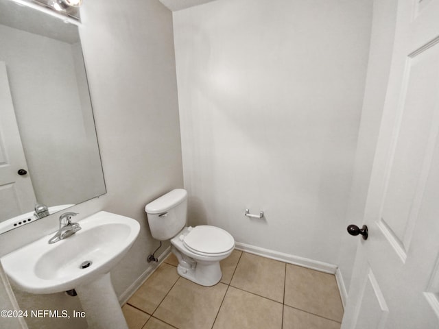 bathroom with sink, toilet, and tile patterned flooring