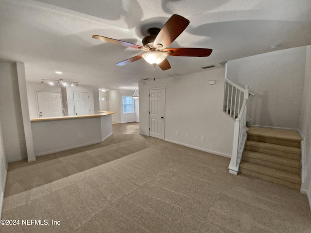 unfurnished living room featuring carpet flooring and ceiling fan