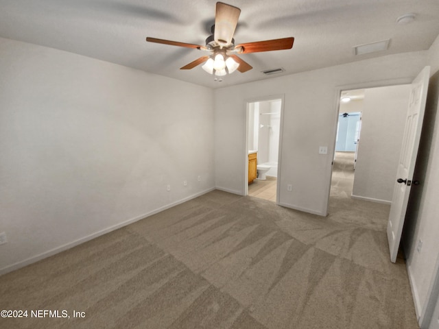 unfurnished bedroom with light carpet, ceiling fan, and ensuite bath