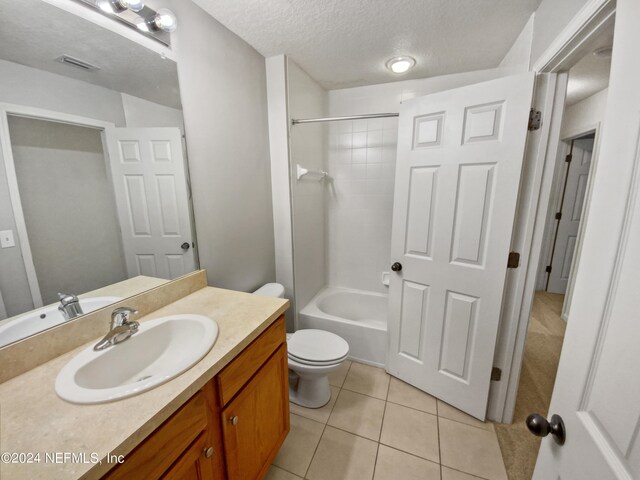 full bathroom featuring tile patterned floors, toilet, shower / bathing tub combination, a textured ceiling, and vanity