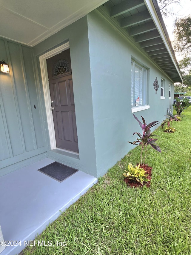 entrance to property featuring a yard