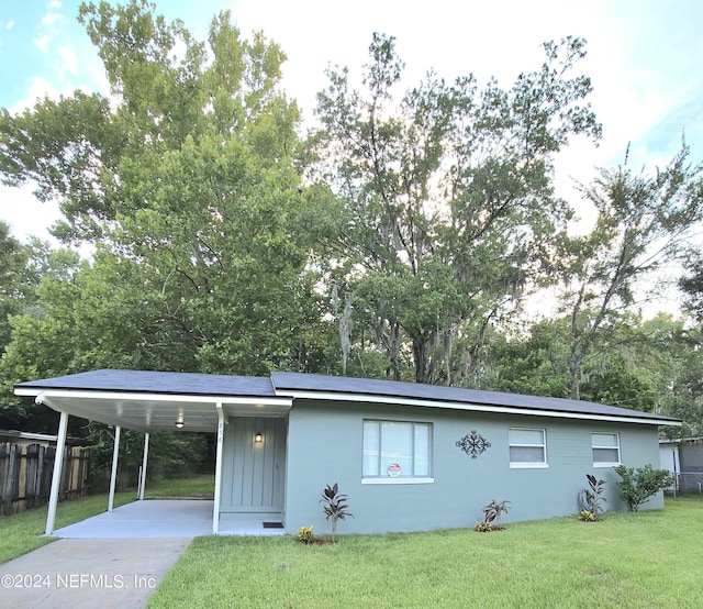 view of front facade featuring a carport and a front lawn