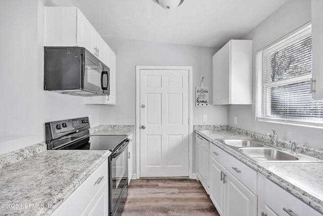 kitchen featuring white cabinetry, hardwood / wood-style flooring, sink, and black appliances