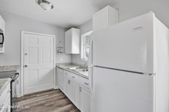 kitchen with white cabinetry, white appliances, dark hardwood / wood-style floors, and sink