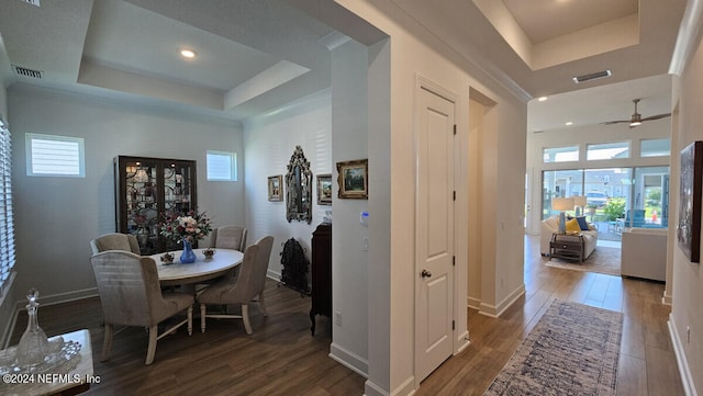 dining area featuring ceiling fan, a raised ceiling, and hardwood / wood-style flooring