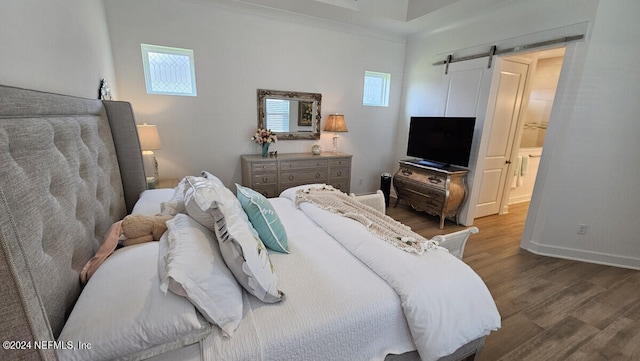 bedroom featuring hardwood / wood-style flooring and a barn door