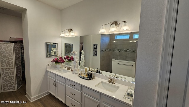 bathroom featuring a tile shower and vanity