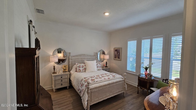 bedroom with a barn door, dark hardwood / wood-style flooring, and crown molding