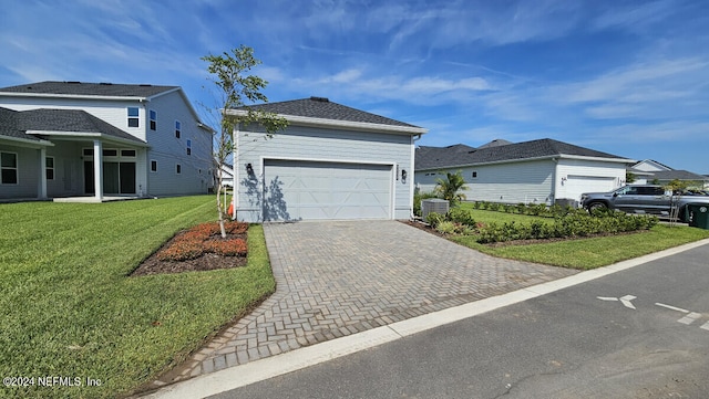 view of front of property with a garage, central AC unit, and a front yard