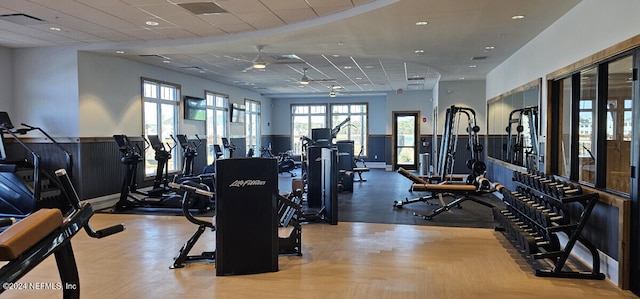 workout area with ceiling fan, a drop ceiling, and light parquet floors