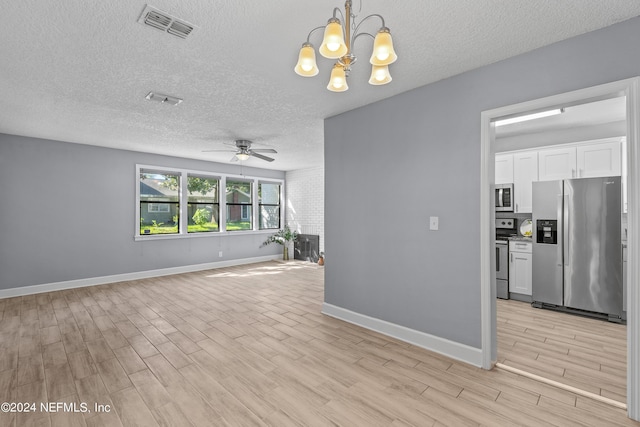 unfurnished living room with ceiling fan with notable chandelier, light hardwood / wood-style floors, and a textured ceiling