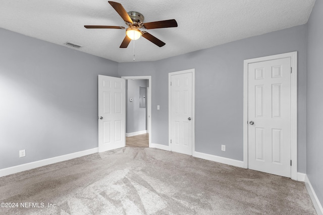 unfurnished bedroom with carpet, a textured ceiling, and ceiling fan