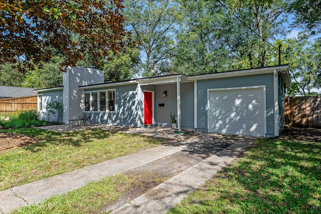 single story home featuring a garage and a front yard